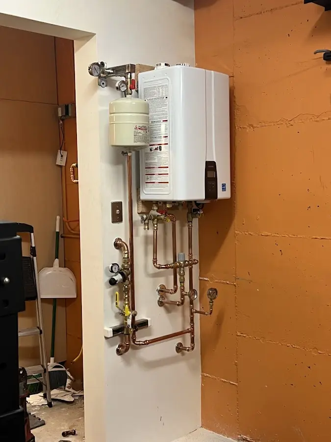 Plumbing technician inspecting water heater connections in West Donegal